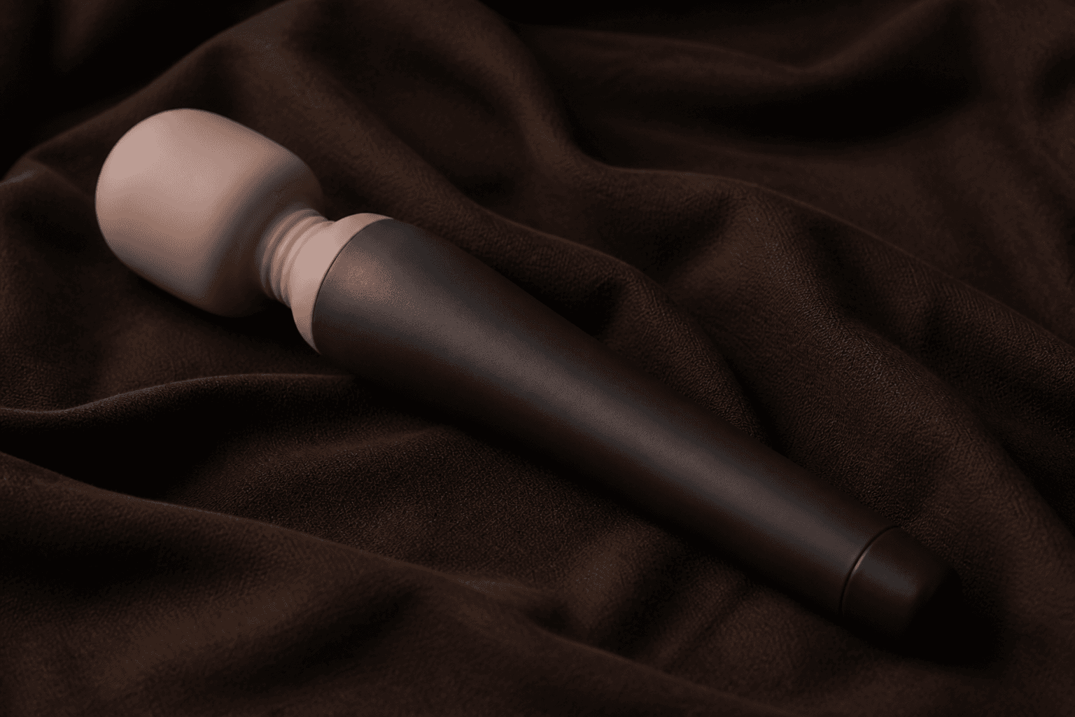 Editorial sample. Full-size wand with a peach silicone head and charcoal handle on dark linen.