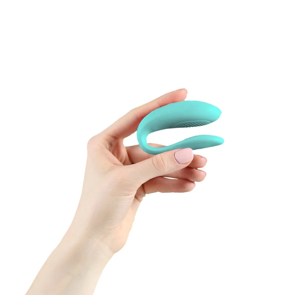 Official We-Vibe Sync Lite in aqua. Slim C-shaped couples vibrator on white.